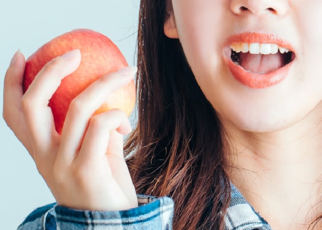 女性がリンゴを持っている画像